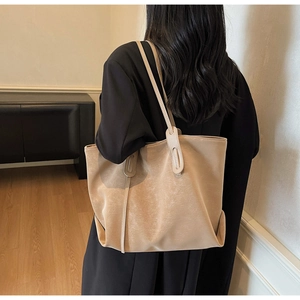 Detailed side view of large vintage tote bag with textured faux leather on model