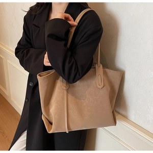 Macro shot of minimalist khaki leather tote bag on shoulder with smooth matte finish