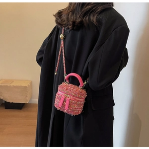 Details von rosa Tweed-Textur und goldener Kette an einer Luxus-Mini-Box-Handtasche