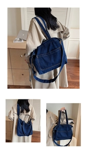 Detail of blue denim tote bag featuring yellow stitching and front pocket design