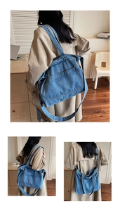 Detail of a large blue denim tote bag featuring dual handles and spacious front pocket