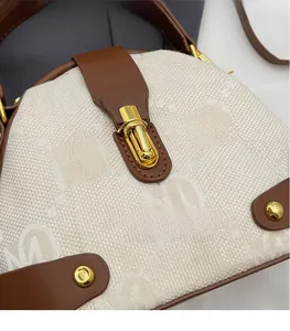 Detail of a half-moon shoulder bag with M-letter jacquard and a gold rotating lock