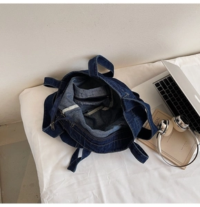 Detail view of deep blue denim tote bag interior showing roomy space and zipper pocket