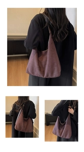 Détail d'un grand sac cabas en daim violet porté avec un manteau en laine noire