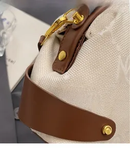 Detail of premium jacquard fabric handbag with brown leather strap and gold rivet accents