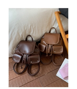 Detail view of vintage leather backpacks in coffee and caramel with contrast stitching