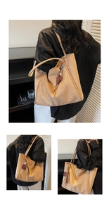 Detail of light brown suede tote bag with long shoulder strap and bear charm accessory