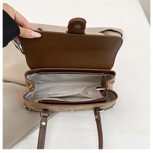 Close-up of brown shoulder bag interior showing zipper pocket and spacious lining