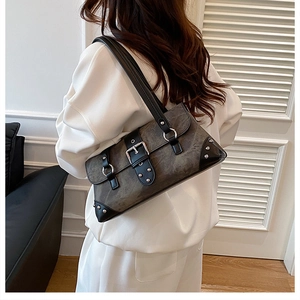Macro detail of charcoal grey vintage baguette bag with silver buckles and metal rivets