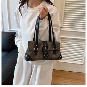 Detailed view of retro shoulder bag with metallic buckle and rivet decorations