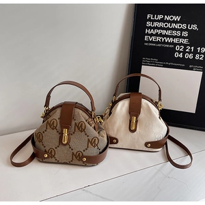 Detail of triangular monogram handbags in brown and beige with gold hardware locks