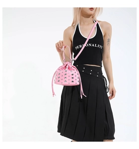 Close-up of pink bucket bag featuring silver rivet studs and a drawstring closure