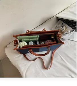 Internal view of large denim and leather tote bag showing spacious compartments and storage