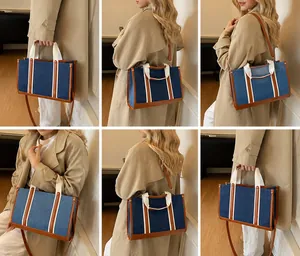 Λεπτομέρεια με στυλ μεταφοράς της τσάντας tote denim με δερμάτινους ιμάντες