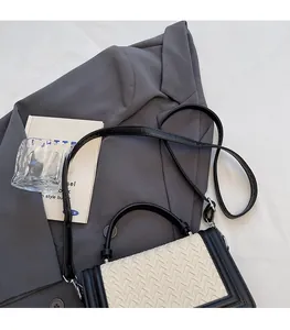 Détail du petit sac tissé avec contraste crème et garniture en cuir noir élégant