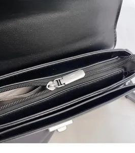 Vue détaillée de l'intérieur du sac en cuir noir avec fermeture éclair argentée et compartiments