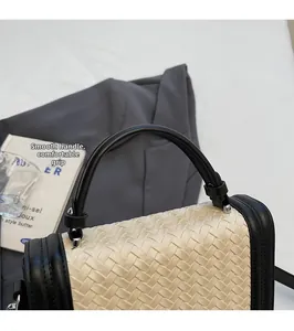 Détail de la poignée ronde et du cuir tressé noir et blanc sur un sac carré chic