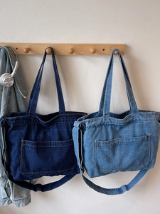 Large capacity denim tote bag with shoulder strap and front pocket in casual minimalist style