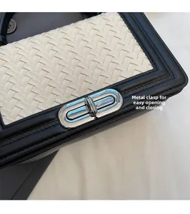 Détail du sac en cuir tressé blanc avec bordure noire et fermoir rotatif argenté