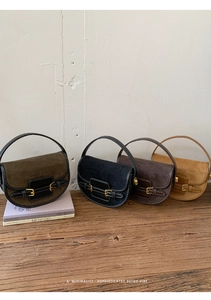 Detailed view of vintage minimalist saddle bags in four colors on a rustic wooden table