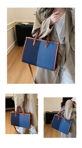 Detail of color-block denim tote bag with brown leather handles and adjustable shoulder strap
