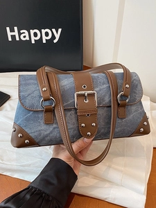Retro denim patchwork underarm bag with brown leather trim and silver metal studs