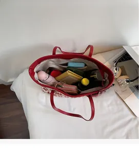 Vue de dessus du cabas imprimé rouge et blanc montrant sa grande capacité et poche zippée