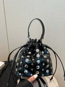 Fashionable black bucket bag with silver studs and chain strap, shown in hand