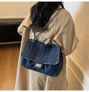 Quilted denim shoulder bag with chain strap shown on a model from a back view