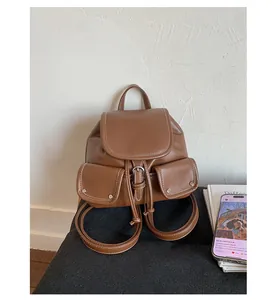 Macro shot of retro brown PU leather backpack with side pockets and silver metal buckles