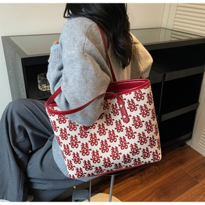 Détail du sac de mariage en toile avec motifs Xi rouges et rivets dorés en métal