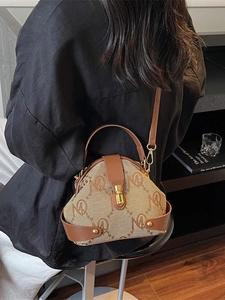 Elegant vintage canvas and leather crossbody bag with top handle for women in a minimalist room