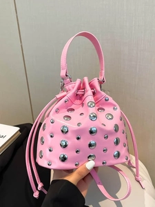 Pink patent leather bucket bag with silver studs and chain strap shown from the front