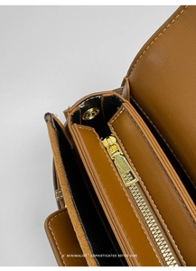 Interior detallado del bolso de silla retro con cremalleras doradas y dos secciones
