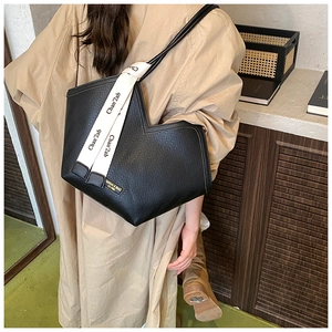 Macro detail of black herringbone patterned tote bag with stylish white ribbon decorative accent