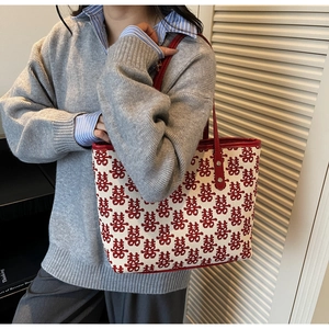 Détails des poignées en cuir rouge et motif Xi brodé sur un grand sac de mariage chinois