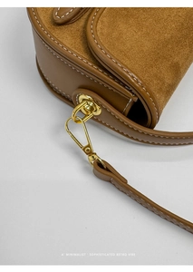 Detalle del bolso de montura marrón con patchwork de ante y costuras en contraste