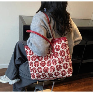 Détail du tissu jacquard Double Bonheur rouge et beige sur un grand sac cabas
