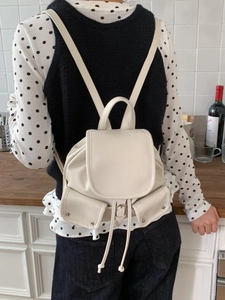 Cream white mini faux leather backpack featuring drawstring closure and front pockets