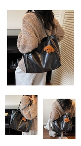 Macro shot of black glossy PU leather tote bag with teddy charm and silk scarf
