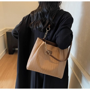 Detail of the woven texture and metal chain strap on this khaki tote bag for women