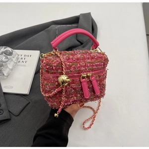 Detail der rosa Tweed-Beuteltasche mit Goldkette und verstellbarer Metallkugel