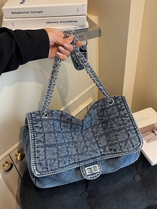 Blue quilted denim shoulder bag with silver chain strap and metal twist lock closure