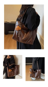 Close-up of vintage brown tote bag featuring soft PU leather and a cute dog charm