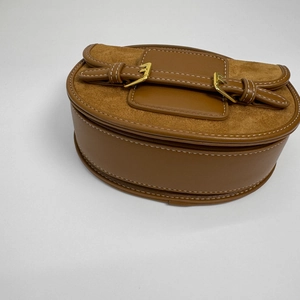 Brown faux leather saddle bag with suede stitching and gold buckle details