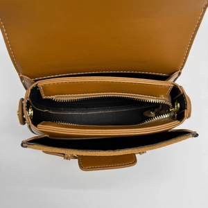 Brown leather saddle bag with multiple internal compartments and gold-toned hardware