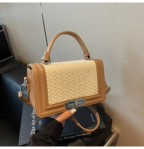 Détail de la texture tissée et du rabat en cuir marron avec fermoir tournant en métal