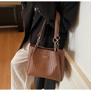 Detailed close-up of brown woven texture on a large tote bag with gold metal hardware