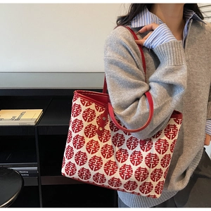 Sac de mariage chinois avec motifs Xi rouges et bordure en cuir porté par un modèle