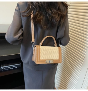 Détail d'un sac bandoulière tissé chic avec garniture kaki porté par un mannequin